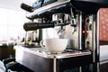 Close-up barista hand inserts the metal filter in the coffee machine, waiting for pouring hot black coffee inside a cup Royalty Free Stock Photo