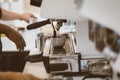 Close-up of barista hand making cup of coffee with coffee maker machine in restaurant or coffee shop. Lifestyles of modern life in