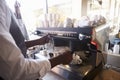 Close Up Of Barista Making Coffee In Deli Using Machine