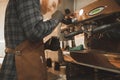 Close-up barista photo of steaming milk for coffee on a professional coffee machine. Barista`s husband warmes the milk in pitcher Royalty Free Stock Photo