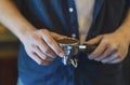 Close up, Barista presses holding espresso handle filled with ground coffee, prepares espresso in his coffee shop