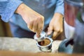 Close up Barista is pressing ground coffee using tamper.