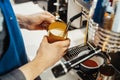 Close up of barista steaming milk in the pitcher with coffee machine. Royalty Free Stock Photo