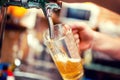 Close-up of barman hand at beer tap pouring a draught beer