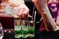 Close up barman hands preparing green mexican cocktail drink at