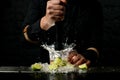 Close-up. Bartender holds madler and energetically squeeze slices of citrus to cocktail Royalty Free Stock Photo