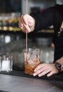 Close up of bartender making cocktail. Barman prepairing cocktail on bar counter.