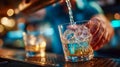 Close-up of a bartender pouring liquid into a glass with splashes and bokeh lights Royalty Free Stock Photo