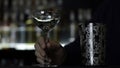 Close up of a bartender putting ice cubes into the small empty cocktail glass. Media. Details of making a drink with Royalty Free Stock Photo