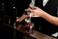 Close-up. Bartender`s hand carefully pours smoky drink from jigger into glass with ice Royalty Free Stock Photo