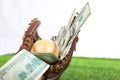 Close up of baseball in a Glove with dollar bills in concept of