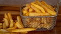 Basket of cooked fries isolated on a wooden background