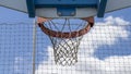 Close-up of a basketball hoop, red, in the open air, the blue sky with fluffy clouds in the background. Royalty Free Stock Photo