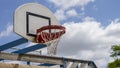 Close-up of a basketball hoop, red, in the open air, the blue sky with fluffy clouds in the background. Royalty Free Stock Photo