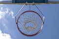 Close-up of a basketball hoop seen from below, blue sky in the background Royalty Free Stock Photo