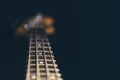 Close-up of a bass guitar fretboard on a blurred dark background Royalty Free Stock Photo