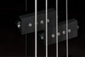 Close-up bass guitar pickups and strings. Musical instruments. Black guitar deck Royalty Free Stock Photo