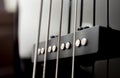 Close-up bass guitar pickups and strings. Musical instruments. Black guitar deck Royalty Free Stock Photo