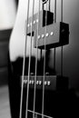 Close-up bass guitar pickups and strings. Musical instruments. Black guitar deck Royalty Free Stock Photo