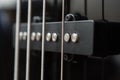 Close-up bass guitar pickups and strings. Musical instruments. Black guitar deck Royalty Free Stock Photo