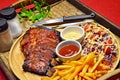 Close up of BBQ RIBS Grilled Steak set with French Fried and Salad on Bamboo Tray Background