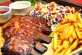 Close up of BBQ RIBS Grilled Steak set with French Fried and Salad on Bamboo Tray Background