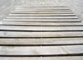 Close up of beach trotter in the sand on the beach. Articulated wooden walkway background. Beige flooring sheets as the best way Royalty Free Stock Photo