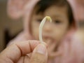 Close up of a bean sprout in a mother`s hand with defocus background of little baby looking at it Royalty Free Stock Photo