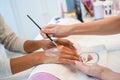 Close-up of beautician applying cream on woman`s hand using brus