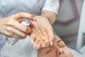 Close-up beautician doctor hands making anti-age procedures, applying cleansing mask lotion for mid-aged female client Royalty Free Stock Photo