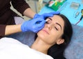 Young beautiful woman making permanent makeup in cosmetology salon. Royalty Free Stock Photo