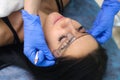 Young beautiful woman making permanent makeup in cosmetology salon. Royalty Free Stock Photo