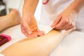 Close-up of a beautician waxing leg of woman with wax strip at a beauty spa Royalty Free Stock Photo