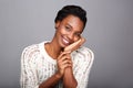 Close up beautiful african american woman smiling and leaning face on hand Royalty Free Stock Photo