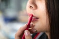 Beautiful asian woman applying red lipstick pencil on her lips Royalty Free Stock Photo