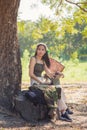 Close up Beautiful Asian woman in casual wear sitting with a laptop under the tree next to a white bicycle in a public park Royalty Free Stock Photo