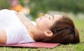 Close up Beautiful Attractive Asian woman practice yoga Dead Body pose or Savasana pose lying on green grass for yoga Meditation f Royalty Free Stock Photo