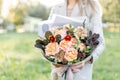 Close-up beautiful autumn bouquet in hands. flower arrangement with various flowers. green lawn on background. Bright Royalty Free Stock Photo