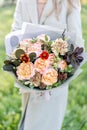 Close-up beautiful autumn bouquet in hands. flower arrangement with various flowers. green lawn on background. Bright Royalty Free Stock Photo