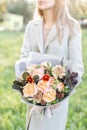 Close-up beautiful autumn bouquet in hands. flower arrangement with various flowers. green lawn on background. Bright Royalty Free Stock Photo