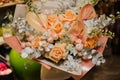 Close-up of beautiful bouquet of calla lilies and orange roses and eucalyptus wrapped in paper