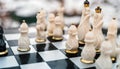 Close up of beautiful chess on table in room. Selective focus of porcelain chess pieces on chessboard