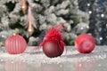 Christmas baubles on a table with an out of focus Christmas tree at the back. Christmas holiday and