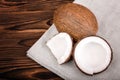 Close-up beautiful coconuts on a brown background. Fresh cut in slices coconut on a gray fabric. Vegetarian ingredients.