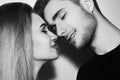 Close-up of beautiful couple kissing. Happy man and girl touching with their noses. Black and white.