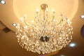 Close up beautiful crystal chandelier lamp with warm light hanging on ceiling . Chrystal chandelier close-up Royalty Free Stock Photo