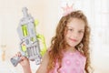 Close up of beautiful curly girl wearin boy clothes and holding in her hands a toy gun