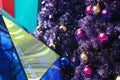 Close up beautiful decorated purple Christmas tree by colorful bauble ball