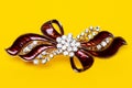 Close-up of a beautiful elegant luxurious hair clip or hair pin with rhinestones on a yellow background. Macro. Royalty Free Stock Photo