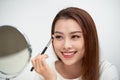 Close up of beautiful face of asian young woman getting make-up. Asian woman is applying eyeshadow on her eyebrow with brush. Royalty Free Stock Photo